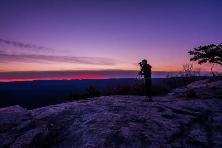 professional photographer adjusting a camera while capturing a creative shot in golden hour lighting. Artistic vision for photographers